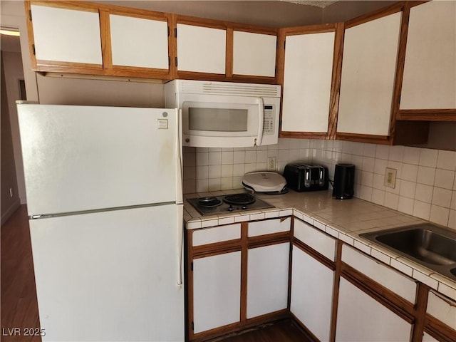 377 N 16th St, Las Vegas, NV 89101 - kitchen featuring white appliances, tile countertops, tasteful backsplash, and white cabinetry