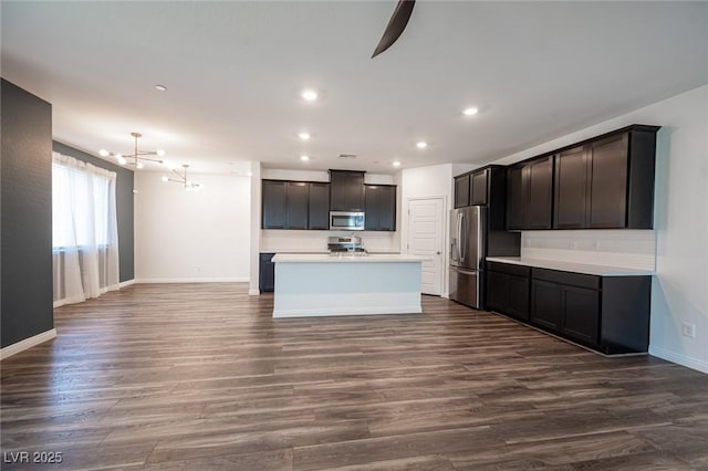 871 Aurelie Ridge St, Henderson, NV 89011 - kitchen with appliances with stainless steel finishes, a chandelier, baseboards, dark wood-style flooring, and light countertops