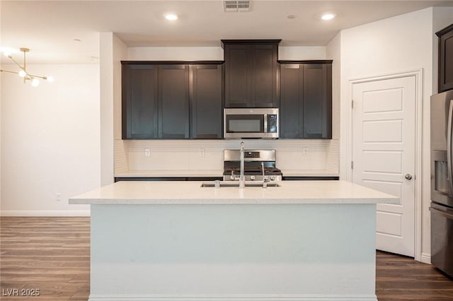 871 Aurelie Ridge St, Henderson, NV 89011 - kitchen featuring stainless steel appliances, decorative backsplash, a sink, dark wood-style flooring, and recessed lighting