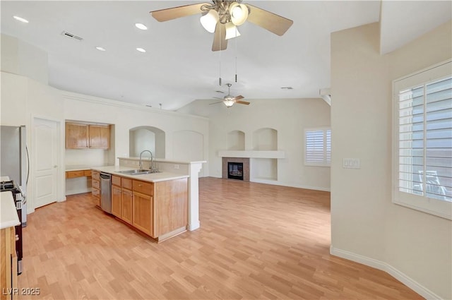 4197 Bottiglia Ave, Las Vegas, NV 89141 - kitchen featuring a sink, dishwasher, ceiling fan, a glass covered fireplace, and light wood-style flooring