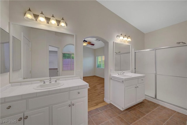 4197 Bottiglia Ave, Las Vegas, NV 89141 - bathroom featuring two vanities, a shower stall, a ceiling fan, and tile patterned flooring