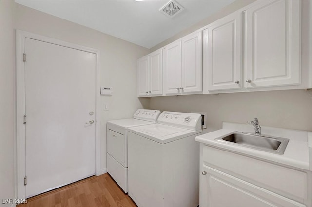 4197 Bottiglia Ave, Las Vegas, NV 89141 - laundry area with independent washer and dryer, cabinet space, and light wood-type flooring