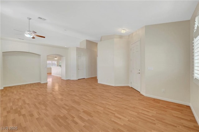 4197 Bottiglia Ave, Las Vegas, NV 89141 - unfurnished living room with a ceiling fan, light wood-style flooring, baseboards, arched walkways, and lofted ceiling