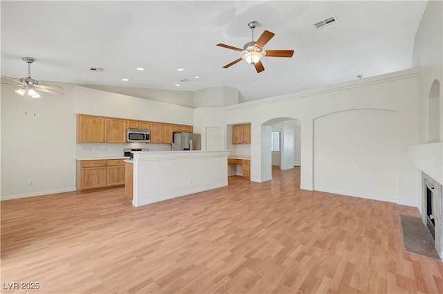 4197 Bottiglia Ave, Las Vegas, NV 89141 - unfurnished living room with a ceiling fan, arched walkways, light wood finished floors, baseboards, and high vaulted ceiling