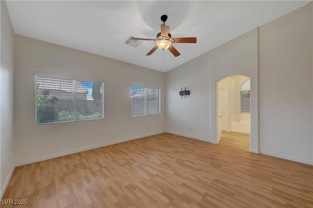 4197 Bottiglia Ave, Las Vegas, NV 89141 - empty room featuring light wood-type flooring, lofted ceiling, arched walkways, ceiling fan, and baseboards