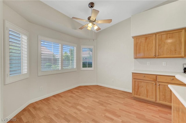 4197 Bottiglia Ave, Las Vegas, NV 89141 - kitchen with light wood-style floors, light countertops, baseboards, ceiling fan, and vaulted ceiling