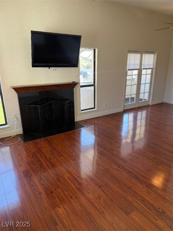 2212 Sunfish Dr Unit D, Henderson, NV 89014 - unfurnished living room featuring a fireplace with flush hearth, wood finished floors, and healthy amount of natural light