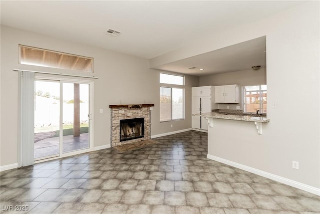 472 Tiger Lily Way, Henderson, NV 89015 - unfurnished living room featuring baseboards and a stone fireplace