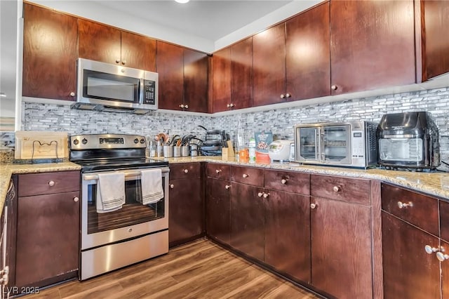 8255 Las Vegas Blvd Unit 719, Las Vegas, NV 89123 - kitchen featuring appliances with stainless steel finishes, dark wood-type flooring, backsplash, and light stone countertops