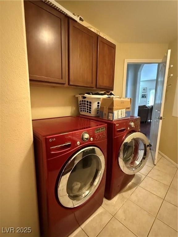 11457 Steponia Bay St, Las Vegas, NV 89141 - laundry room featuring cabinet space, washing machine and clothes dryer, and light tile patterned floors