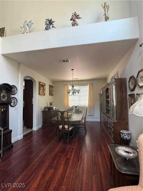11457 Steponia Bay St, Las Vegas, NV 89141 - dining area with wood finished floors, arched walkways, and a chandelier