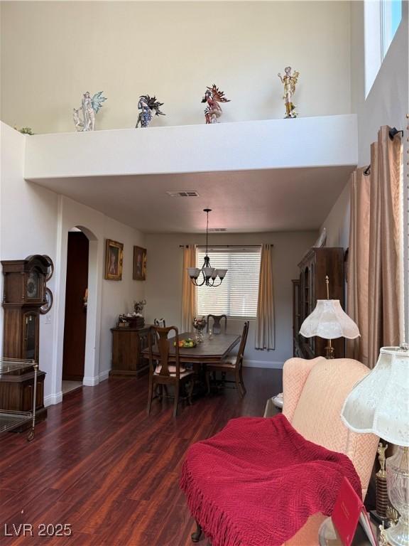 11457 Steponia Bay St, Las Vegas, NV 89141 - dining area featuring arched walkways, wood finished floors, a chandelier, and a high ceiling