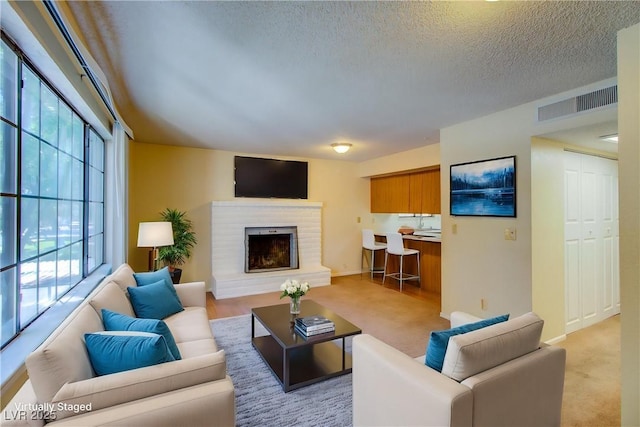1316 Capri Drive A,B,C,&D, Boulder City, NV 89005 - living room featuring a brick fireplace, a textured ceiling, light carpet, and baseboards