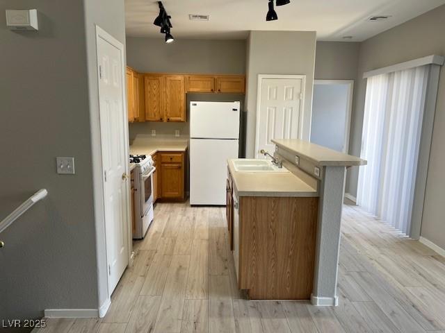 6170 E Sahara Ave Unit 1012, Las Vegas, NV 89142 - kitchen featuring white appliances, light wood-type flooring, light countertops, and an island with sink