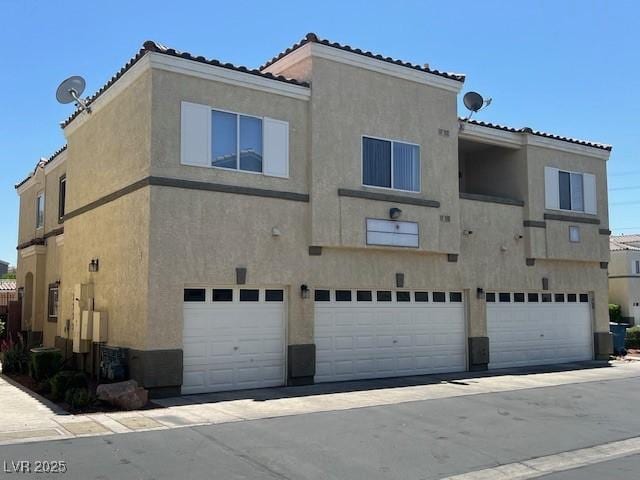 6170 E Sahara Ave Unit 1012, Las Vegas, NV 89142 - back of house featuring an attached garage, stucco siding, and a tiled roof
