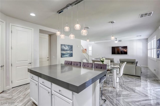 459 Astillero St, Las Vegas, NV 89138 - kitchen with dark countertops, baseboards, white cabinets, recessed lighting, and hanging light fixtures