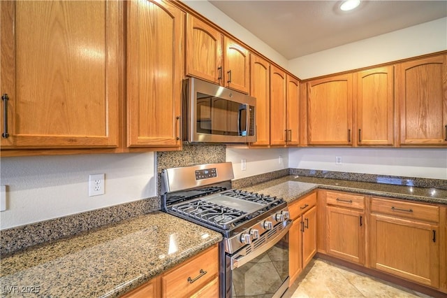 2144 Marywood Park Ct, Henderson, NV 89044 - kitchen featuring appliances with stainless steel finishes, dark stone counters, and brown cabinetry