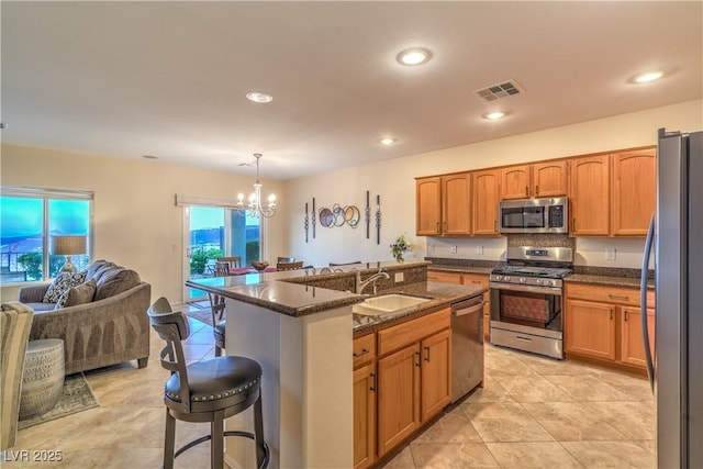 2144 Marywood Park Ct, Henderson, NV 89044 - kitchen featuring appliances with stainless steel finishes, a sink, a breakfast bar, a chandelier, and open floor plan