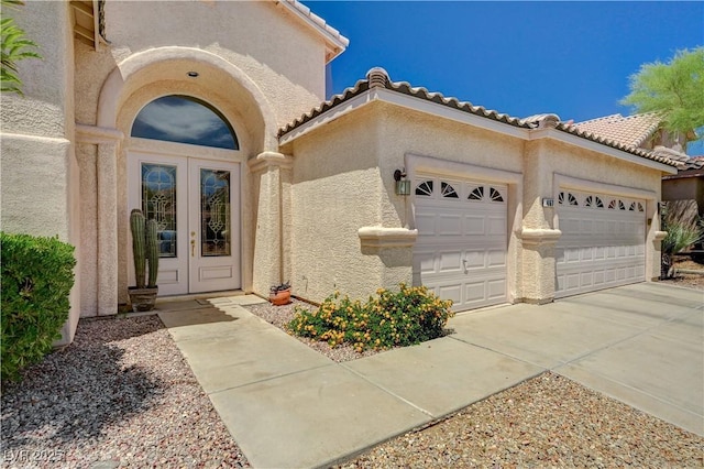 467 Beardsley Cir, Henderson, NV 89052 - view of exterior entry featuring french doors, an attached garage, stucco siding, and concrete driveway