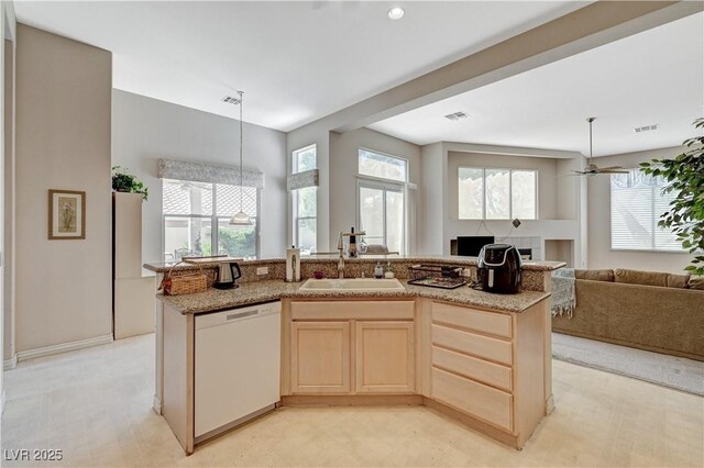 467 Beardsley Cir, Henderson, NV 89052 - kitchen with white dishwasher, a sink, light brown cabinetry, open floor plan, and pendant lighting