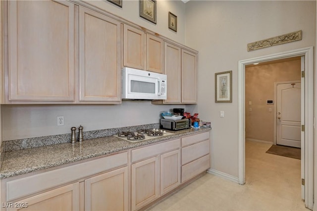 467 Beardsley Cir, Henderson, NV 89052 - kitchen with white appliances, light brown cabinets, light stone countertops, and baseboards