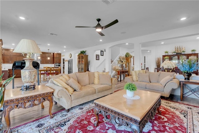 7260 Grace Estate Ave, Las Vegas, NV 89113 - living room with ceiling fan, arched walkways, light wood finished floors, recessed lighting, and stairs