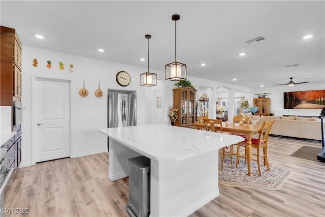 7260 Grace Estate Ave, Las Vegas, NV 89113 - kitchen with appliances with stainless steel finishes, a ceiling fan, light wood-style flooring, a kitchen island, and recessed lighting