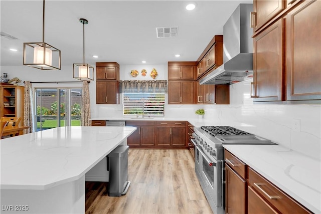 7260 Grace Estate Ave, Las Vegas, NV 89113 - kitchen featuring appliances with stainless steel finishes, wall chimney range hood, light wood finished floors, light stone countertops, and decorative light fixtures