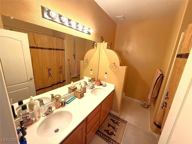6351 Davidson Ct, Las Vegas, NV 89110 - bathroom featuring double vanity, a textured wall, tile patterned flooring, toilet, and a shower with curtain