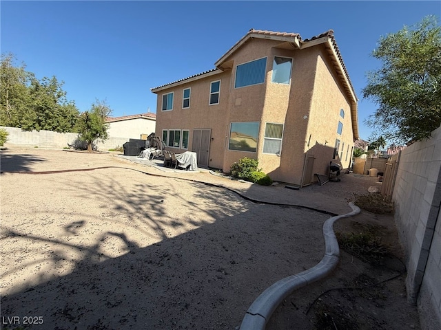 6351 Davidson Ct, Las Vegas, NV 89110 - rear view of property featuring stucco siding, a fenced backyard, a tiled roof, and a patio