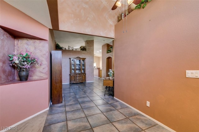 1017 Guided Dancer Ave, Henderson, NV 89015 - corridor with baseboards, arched walkways, tile patterned floors, and a towering ceiling