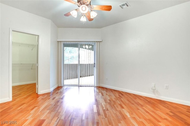 8725 Red Rio Dr Unit 203, Las Vegas, NV 89128 - unfurnished bedroom featuring a walk in closet, light wood-type flooring, and baseboards