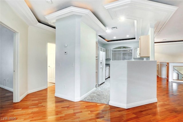 8725 Red Rio Dr Unit 203, Las Vegas, NV 89128 - kitchen with light wood finished floors, a raised ceiling, crown molding, white appliances, and white cabinetry
