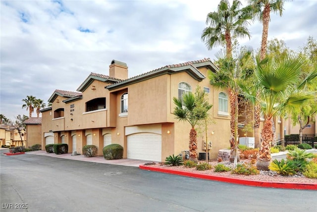 8725 Red Rio Dr Unit 203, Las Vegas, NV 89128 - view of building exterior featuring a garage