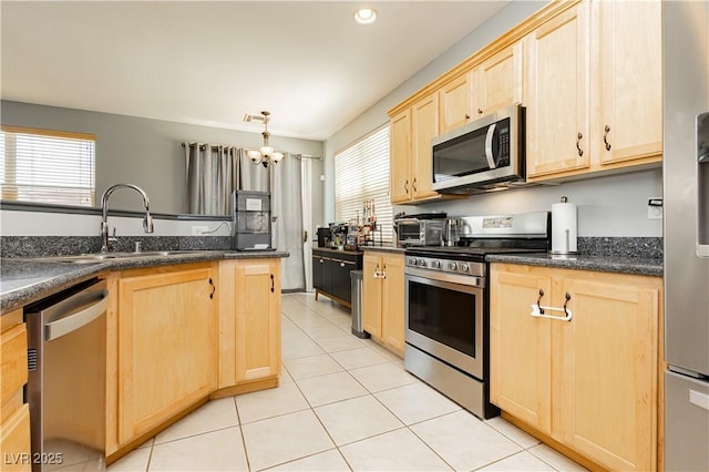 561 Fork Mesa Ct, Henderson, NV 89015 - kitchen featuring light brown cabinetry, appliances with stainless steel finishes, a chandelier, light tile patterned flooring, and a sink