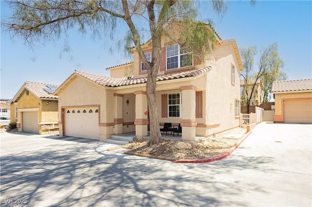 561 Fork Mesa Ct, Henderson, NV 89015 - mediterranean / spanish-style house featuring stucco siding, a tile roof, an attached garage, and a porch