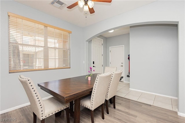 561 Fork Mesa Ct, Henderson, NV 89015 - dining area with arched walkways, a ceiling fan, baseboards, and light wood-style floors