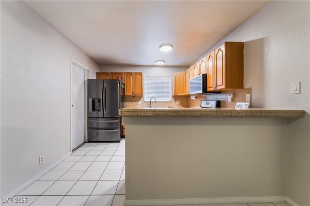 6608 Burgundy Way, Las Vegas, NV 89107 - kitchen with black fridge with ice dispenser, a peninsula, a sink, range, and baseboards
