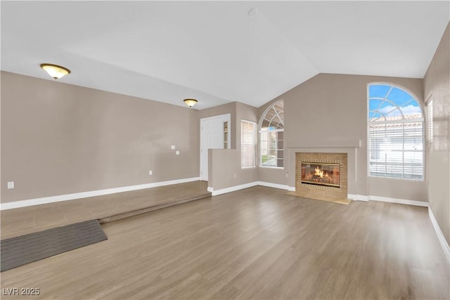 104 Hutton Ln, Las Vegas, NV 89145 - unfurnished living room featuring wood finished floors, a fireplace with flush hearth, baseboards, and lofted ceiling