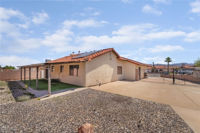 411 Monmouth Ct, Henderson, NV 89015 - back of property with a fenced backyard, roof mounted solar panels, a patio, stucco siding, and driveway