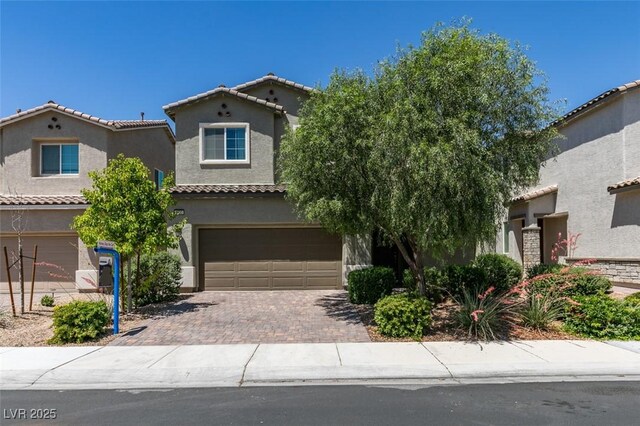 4633 Fragrant St, North Las Vegas, NV 89031 - mediterranean / spanish-style house with an attached garage, stucco siding, decorative driveway, and a tile roof