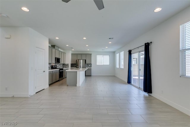 4633 Fragrant St, North Las Vegas, NV 89031 - kitchen featuring appliances with stainless steel finishes, open floor plan, light countertops, ceiling fan, and baseboards