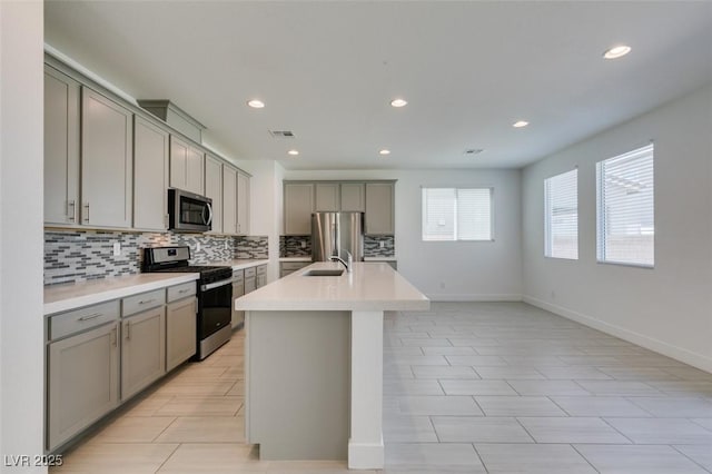 4633 Fragrant St, North Las Vegas, NV 89031 - kitchen with stainless steel appliances, gray cabinets, a sink, backsplash, and recessed lighting