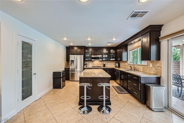 529 Caribbean Palm Dr, Las Vegas, NV 89138 - kitchen featuring stainless steel appliances, a sink, healthy amount of natural light, tasteful backsplash, and a textured ceiling