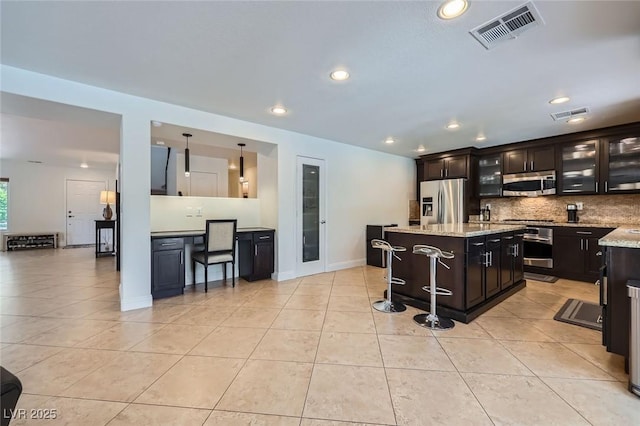 529 Caribbean Palm Dr, Las Vegas, NV 89138 - kitchen featuring stainless steel appliances, backsplash, light tile patterned floors, recessed lighting, and a kitchen island