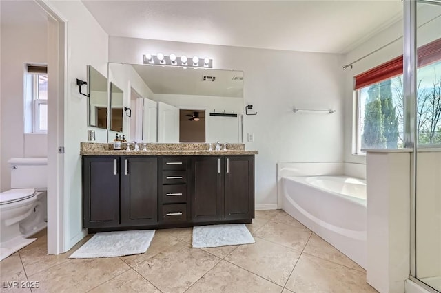 529 Caribbean Palm Dr, Las Vegas, NV 89138 - full bathroom featuring a garden tub, double vanity, toilet, tile patterned flooring, and baseboards