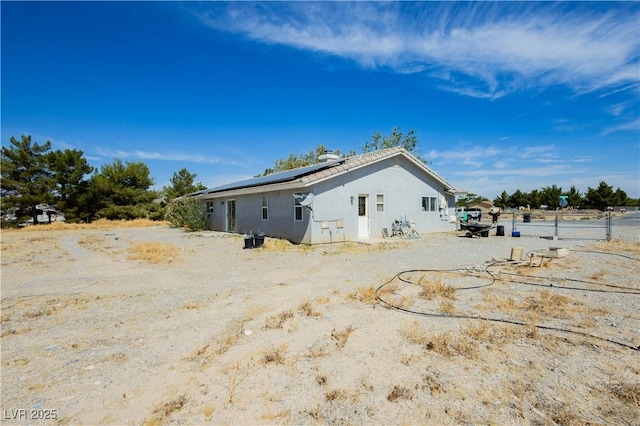 2251 Bridger St, Pahrump, NV 89048 - rear view of house with solar panels and stucco siding