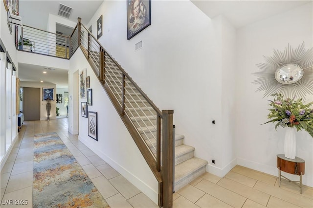 10297 Sierra Skye Ave, Las Vegas, NV 89166 - stairway featuring baseboards, tile patterned flooring, and a towering ceiling