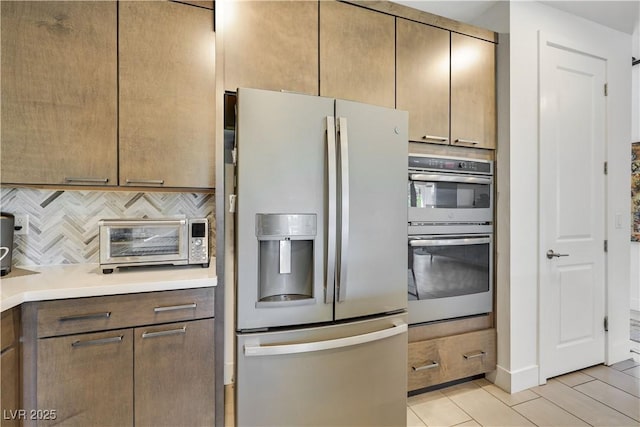 10297 Sierra Skye Ave, Las Vegas, NV 89166 - kitchen featuring fridge with ice dispenser, double oven, tasteful backsplash, light countertops, and light tile patterned flooring