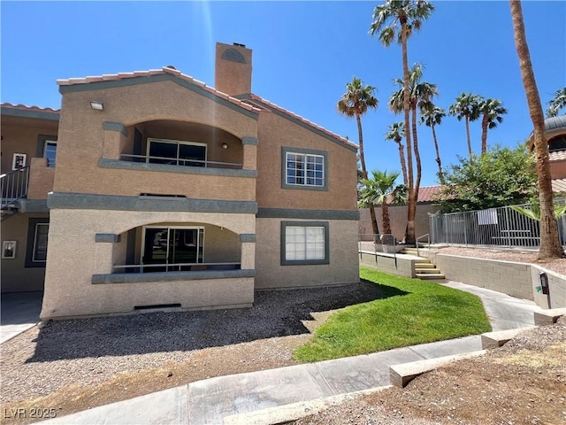 5260 Mission Monterey Ln Unit 208, Las Vegas, NV 89107 - view of side of home with a balcony, stucco siding, and a chimney